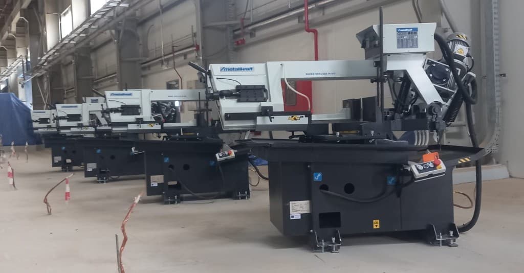 Row of Metallkraft industrial band saws installed in a factory workshop