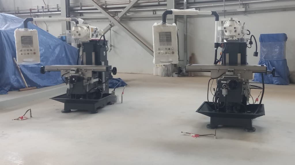 Pair of milling machines newly installed side by side on a factory floor