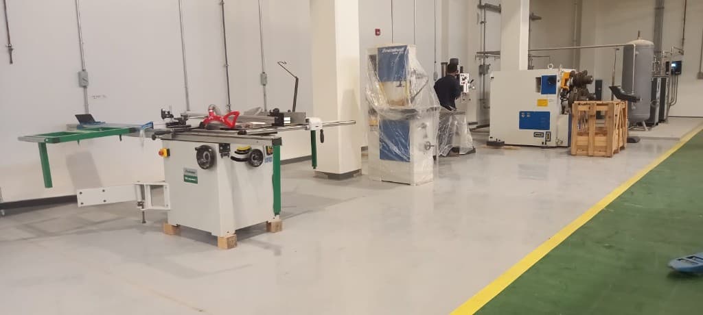 Industrial woodworking workshop floor with sliding table saw and production machines